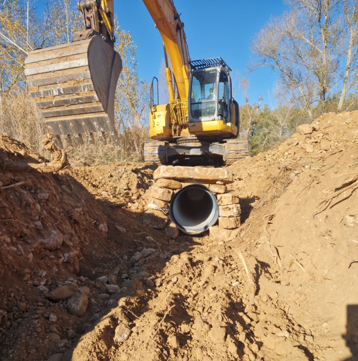 Excavadora treballant en l'excavació d'una rasa per a la instal·lació de canonades a URL: https://www.excavacionsjrovira.com/